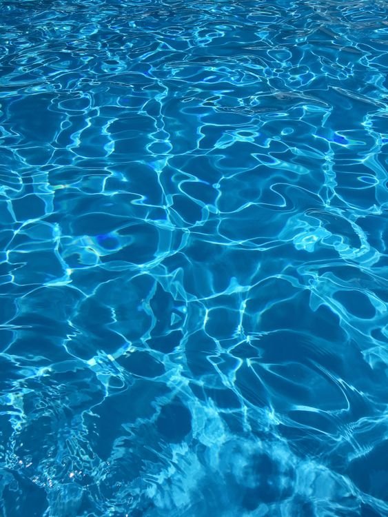 Água azul de piscina com reflexos de luz
