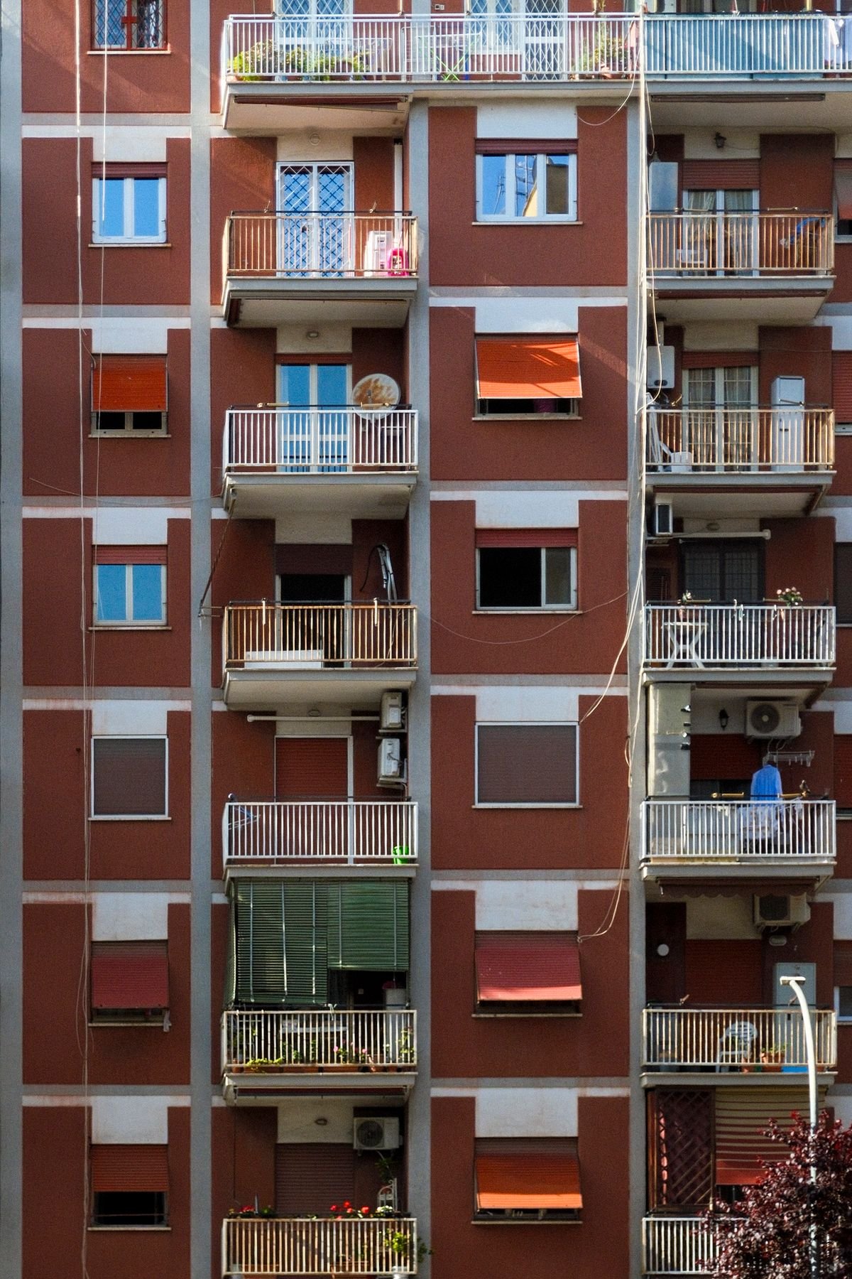 Fachada de edifício de apartamentos com varandas e diferentes modelos de janelas
