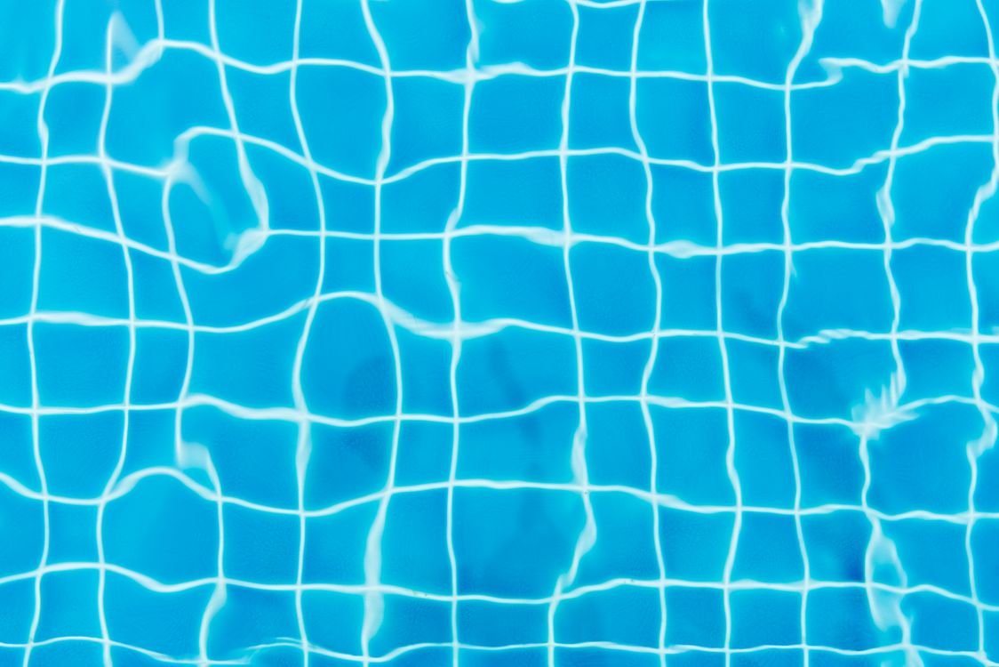 Piscina residencial com água azul e borda de pedra