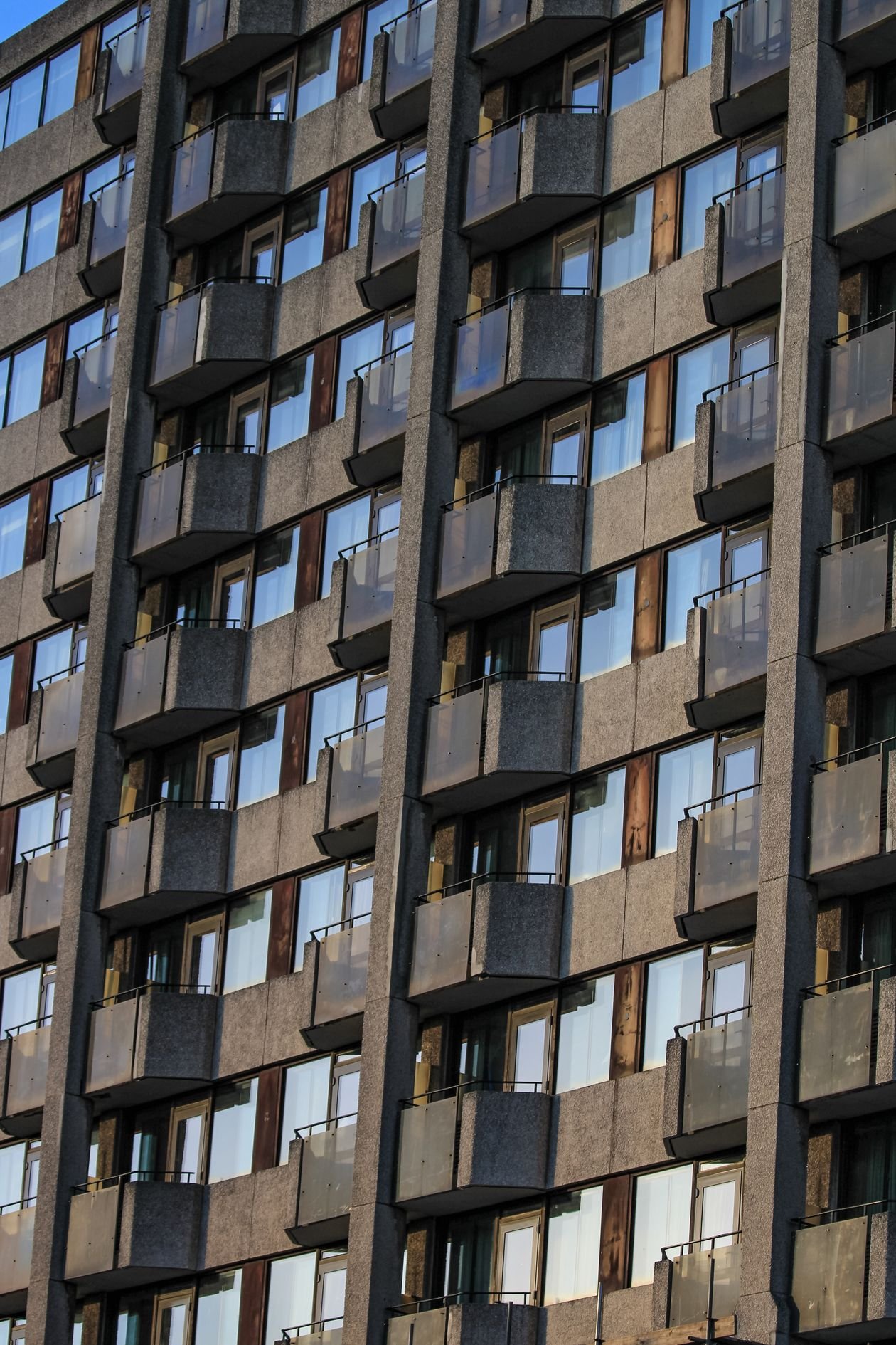 Fachada de prédio residencial com varandas e janelas de vidro