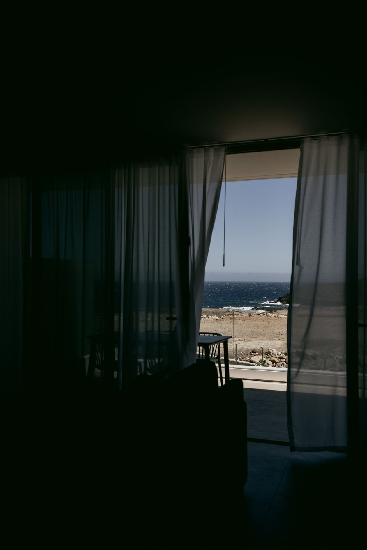Vista do mar através de janela em apartamento à beira-mar na orla de Salvador